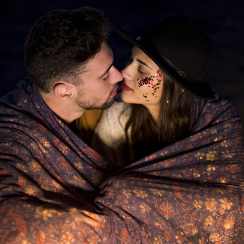 young-couple-blanket-sitting-sandy-sea-shore